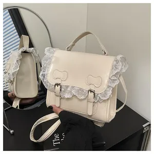 Detailed close-up of cream lace edges and bow accents on a stylish women's shoulder bag