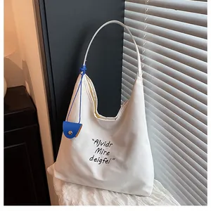 Detail of minimalist off-white canvas tote bag with a small blue pouch for daily use