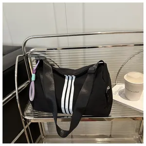 Detailed shot of a black fitness duffel bag with white stripes and purple cord accents