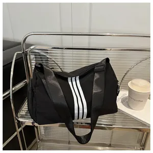 Macro detail of black nylon fitness bag featuring iconic triple white vertical stripes