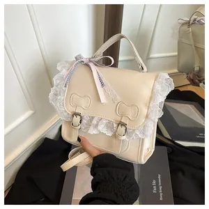 Close-up of the elegant white lace trim and decorative bow clasp on the stylish handbag