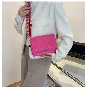 Detail of rose pink crossbody bag featuring triangular quilting and a wide patterned strap