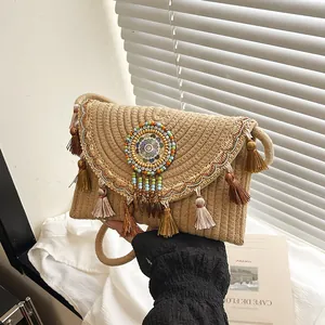 Handgemaakte bohemien rieten crossbodytas met etnisch borduurwerk en kleurrijke kwastjes