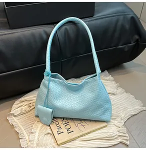 Detail of light blue woven hobo bag featuring geometric texture and matching mini pouch charm