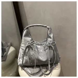 Detailansicht der silbernen Schleifenhandtasche mit Doppelreißverschluss und Hochglanz
