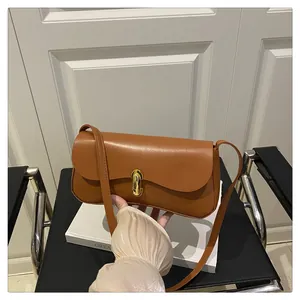 Detail of caramel leather shoulder bag with a gold metal twist lock and sleek square design