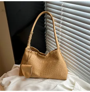 Detailed view of khaki woven shoulder bag with intricate Intrecciato pattern and coin purse