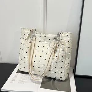 Chic off-white bow pattern tote bag with pearl pendant and stylish pleat texture