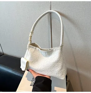 Detail of cream woven leather hobo bag featuring a detachable matching coin purse charm
