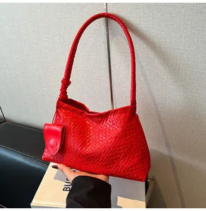 Detail of red woven leather bucket bag with matching small coin purse and braided strap