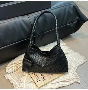 Detail of black woven leather hobo bag featuring knot handle and intricate texture