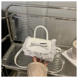 Detail of white mini bow bag featuring lace trim edges and premium PU leather texture