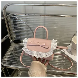 Close-up of pink mini handbag with white lace trim and bow on metal display stand
