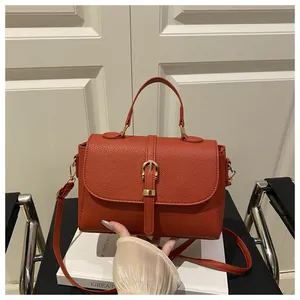 Close-up of caramel lychee grain leather bag with gold buckle and adjustable strap