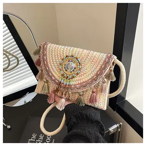 Detail van bohemien geweven tas met kleurrijk borduurwerk, kralen en franjes