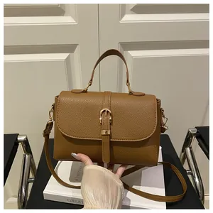 Detail of caramel lychee grain crossbody bag with gold buckle and adjustable strap