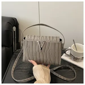 Close-up of gray crocodile-embossed PU handbag with silver V-shaped metallic buckle detail