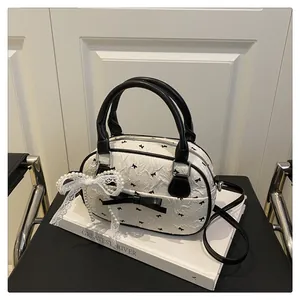 Detail of white wrinkled bag with black bow and lace pearl butterfly charm decoration
