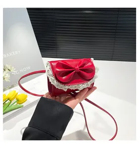 Detailed shot of red leather mini bag featuring sweet bow and white lace trim