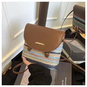Detail of rainbow straw bucket bag with leather flap and metal logo for summer styling
