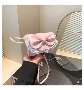 Detailed close-up of pink mini handbag featuring a large bow and white lace trim