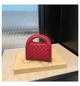 Detail of red quilted leather mini bag with silver chain strap and top handle