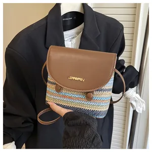 Detail of multi-color woven straw bucket bag featuring a brown faux leather magnetic lid