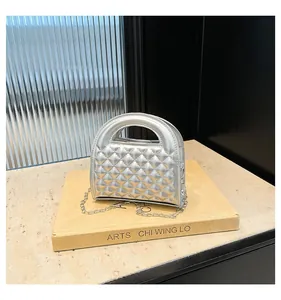 Detailed macro view of silver quilted mini handbag with metallic finish and chain strap