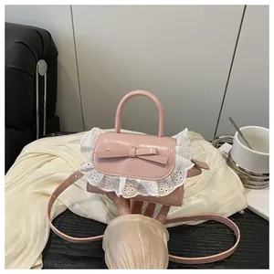Detailed macro shot of a pink mini crossbody bag with leather bow and lace trim details