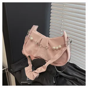 Detail view of pink pleated underarm bag with pearl chain and silver floral charms