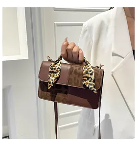 Detail showing retro brown shoulder bag with leopard print scarf wrap on handle