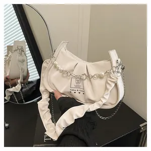 Detail of off-white pleated baguette bag with pearl chain and brand logo tag