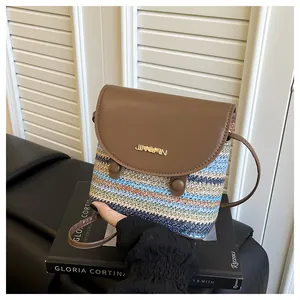 Close-up of rainbow woven straw body and brown leather flap with gold logo hardware