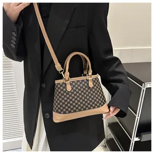 Classic checkered crossbody bag with gold hardware shown on a model in a black suit