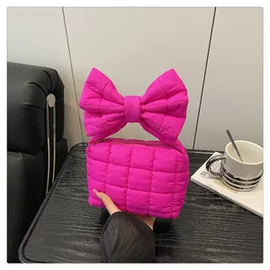 Detailed close-up of quilted hot pink bubble handbag featuring a large bow-knot handle