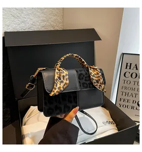 Detailed close-up of a black crossbody bag with leopard print texture in a gift box