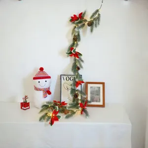 Christmas pine needle garland with red poinsettia and LED lights for festive decor