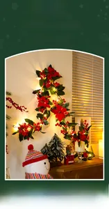 Detail view of warm LED Christmas garland with red poinsettia flowers and festive berries