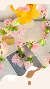 Macro detail of warm white cherry blossom LED string lights with realistic green leaves