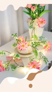 Détail de guirlandes LED dahlias roses avec feuilles vertes et lueur de fil de cuivre chaud