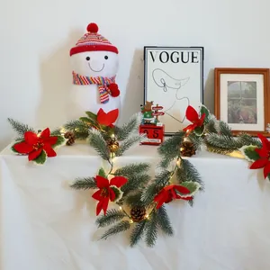 Artificial Christmas garland with pine needles, red poinsettias, cones and warm LED lights