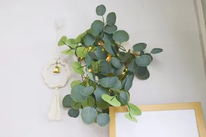 Détail de guirlande LED eucalyptus avec anneau tissé boho et glands blancs