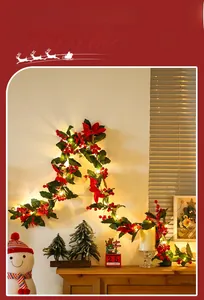 Detail of festive Christmas garland with red berries, poinsettia flowers and LED lights