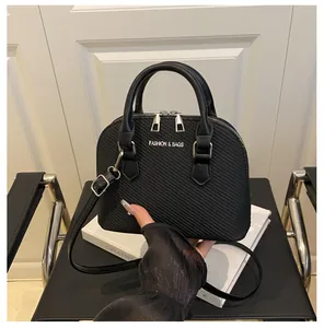 Detail of black crocodile texture shell bag with silver metallic Fashion & Bags logo