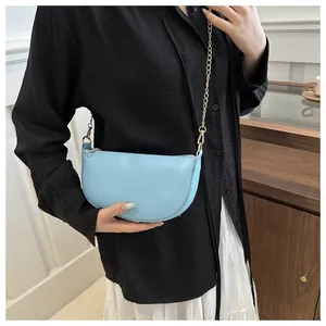 Detailansicht der hellblauen Halbmond-Tasche aus Leder mit eleganter goldener Kette