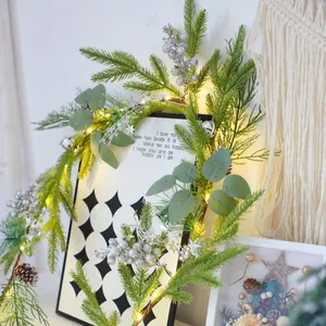 Detail of Christmas garland with LED lights, eucalyptus leaves, silver berries and pinecones