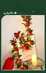 Macro view of Christmas garland with LED lights, red berries and festive flowers