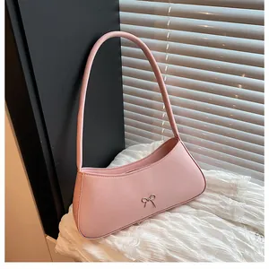 Nahaufnahme der rosa Baguette-Tasche mit silberner Metallschleife auf Kunstleder