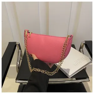 Detail der rosa halbmondförmigen Ledertasche mit Litschi-Struktur und goldener Kette