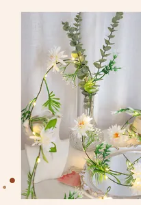 Détail d'une guirlande LED avec pâquerettes blanches et feuilles vertes pour décoration